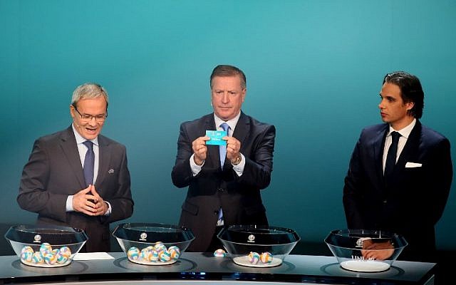 Former Irish footballer Ronnie Whelan (C) holds up a slip of paper after drawing France from the pot flanked by UEFA deputy secretary general Giorgio Marchetti (L) and former Portuguese footballer Nuno Gomes (R) during the UEFA Euro 2020 football competition qualifying draw in Dublin on December 2, 2018. (Photo by Paul FAITH / AFP) Former Irish footballer Ronnie Whelan (C) holds up a slip of paper after drawing France from the pot flanked by UEFA deputy secretary general Giorgio Marchetti (L) and former Portuguese footballer Nuno Gomes (R) during the UEFA Euro 2020 football competition qualifying draw in Dublin on December 2, 2018. (Photo by Paul FAITH / AFP)