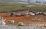 A picture taken on December 5, 2018, from a position near the southern Lebanese village of Kfar Kila shows members of the Israeli military, excavators, trailers, and other vehicles operating on the other side of the border. (Ali Dia/AFP)