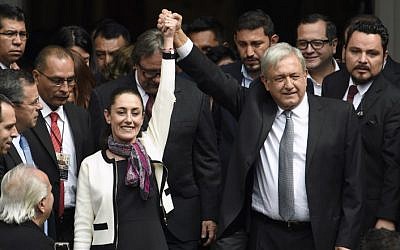 Mexican President Andres Manuel Lopez Obrador (R) raises the hand of Mexico City's new mayor Claudia Sheinbaum (L), after her swearing-in ceremony at the local Congress in Mexico City on December 05, 2018 (ALFREDO ESTRELLA / AFP)