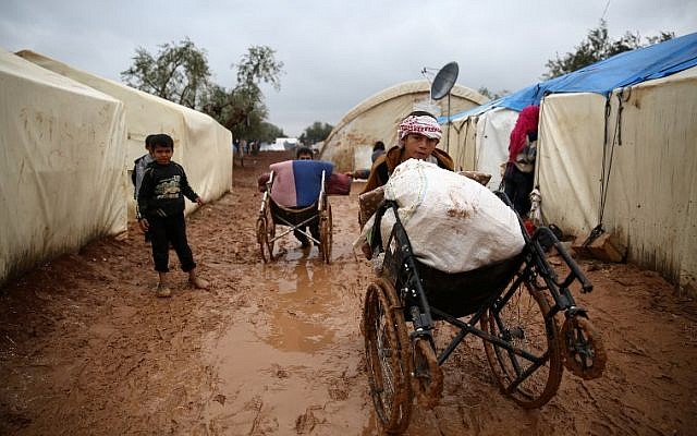 Syrian children walk in the mud after heavy rain at a displacement camp outside Shamarin, near the border with Turkey in the northern Aleppo province, on December 6, 2018. (Nazeer AL-KHATIB / AFP) Syrian children walk in the mud after heavy rain at a displacement camp outside Shamarin, near the border with Turkey in the northern Aleppo province, on December 6, 2018. (Nazeer AL-KHATIB / AFP)