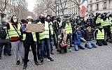 A protester holds a sign reading "Macron stop hiding" near the Champs Elysees avenue in Paris on December 8, 2018 during a "yellow vests" (gilets jaunes) demonstration protesting rising costs of living they blame on high taxes. (Thomas Samson/AFP)