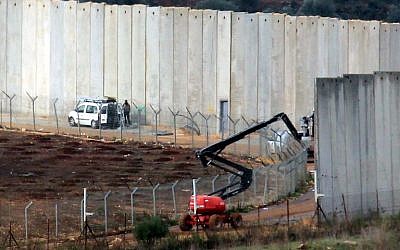 Israeli machinery operates next to a concrete wall separating Israel and Lebanon, in a photograph taken from the southern Lebanese village of Kfar Kila, near the border with Israel, on December 9, 2018. (Ali Dia/AFP)