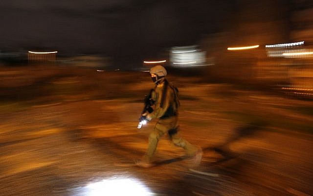 An Israeli soldier walks during clashes with Palestinian protesters in the West Bank city of Ramallah on December 11, 2018. (ABBAS MOMANI / AFP)
