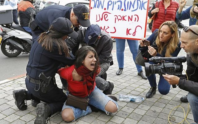 A woman scuffles with police trying to disperse demonstrators from the middle of the street during a rally against domestic violence inTel Aviv on December 12, 2018. (JACK GUEZ / AFP) A woman scuffles with police trying to disperse demonstrators from the middle of the street during a rally against domestic violence inTel Aviv on December 12, 2018. (JACK GUEZ / AFP)