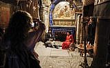 A couple poses for a picture in front of the Grotto of the Nativity, the place where Jesus is said to have been born, inside the Church of the Nativity in the West Bank city of Bethlehem on December 12, 2018. (Thomas Coex/AFP)