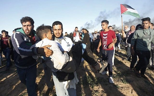 A Palestinian carries a young man away from demonstrations on the border between Israel and Khan Yunis in the southern Gaza Strip, on December 14, 2018. (Said Khatib/AFP) A Palestinian carries a young man away from demonstrations on the border between Israel and Khan Yunis in the southern Gaza Strip, on December 14, 2018. (Said Khatib/AFP)