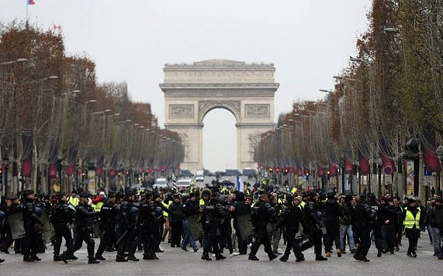 French riot police take position in front of "yellow vest" protesters on the Champs-Elysees in Paris, on December 15, 2018. (Valery Hache/AFP) French riot police take position in front of "yellow vest" protesters on the Champs-Elysees in Paris, on December 15, 2018. (Valery Hache/AFP)