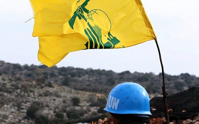 A picture taken from the southern Lebanese village of Meiss al-Jabal on December 16, 2018, shows a United Nations Interim Forces in Lebanon (UNIFIL) soldier monitoring the border between Lebanon and Israel. On his right is a flag of the Lebanese Shiite terror group Hezbollah. (Mahmoud Zayyat/AFP) A picture taken from the southern Lebanese village of Meiss al-Jabal on December 16, 2018, shows a United Nations Interim Forces in Lebanon (UNIFIL) soldier monitoring the border between Lebanon and Israel. On his right is a flag of the Lebanese Shiite terror group Hezbollah. (Mahmoud Zayyat/AFP)