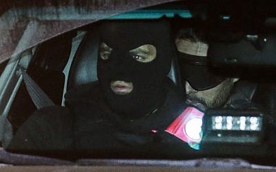 French national Mehdi Nemmouche, right, sits in the back of a police vehicle as he arrives at the courthouse in Brussels on December 20, 2018, for a preliminary hearing in his trial for killing four people in a terror attack at the city's Jewish Museum . (Thierry Roge/Belga/AFP)
