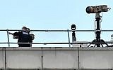 Police officers stand near equipment on the rooftop of a building at London Gatwick Airport, south of London, on December 21, 2018. (Ben Stansall/AFP)