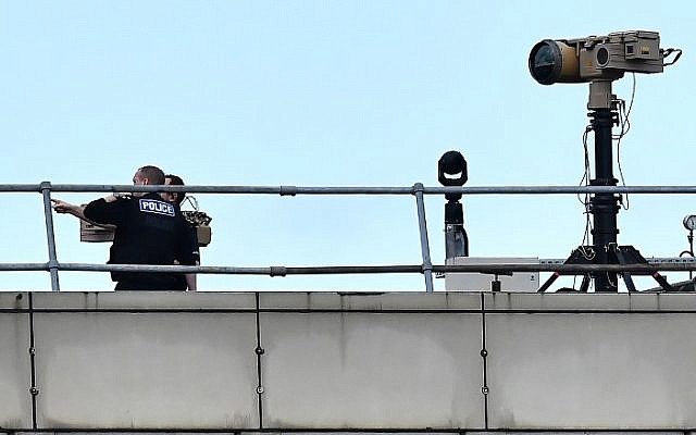 Police officers stand near equipment on the rooftop of a building at London Gatwick Airport, south of London, on December 21, 2018. (Ben Stansall/AFP) Police officers stand near equipment on the rooftop of a building at London Gatwick Airport, south of London, on December 21, 2018. (Ben Stansall/AFP)