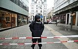 A police officer secures the crime scene where a person died and an other has been injured by gunshots in the historic center in Vienna, Austria, on December 21, 2018. (Georg Hochmuth/APA/AFP)