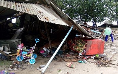 Residents look for salvageable items in their destroyed homes on Carita beach, Indonesia, on December 23, 2018, after the area was hit by a tsunami on December 22 triggered by an eruption of the Anak Krakatoa volcano, which killed dozens and injured hundreds more as it slammed without warning into tourist beaches and coastal areas around Sunda Strait, sending panicked holiday makers and residents fleeing. (Semi/AFP)