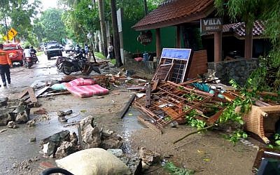 Debris from damaged buildings is seen on a street on Carita beach, Indonesia, on December 23, 2018, after the area was hit by a tsunami on December 22 triggered by an eruption of the Anak Krakatoa volcano, which killed dozens and injured hundreds more as it slammed without warning into tourist beaches and coastal areas around Sunda Strait, sending panicked holiday makers and residents fleeing. (Ronald/AFP)