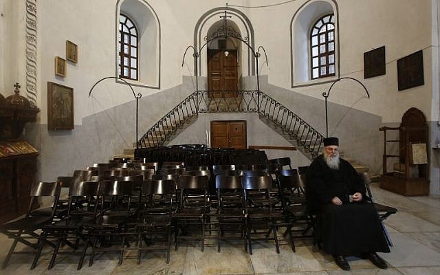 A priest prays inside the Nativity church in the West Bank town of Bethlehem.December 24,2018. (HAZEM BADER/AFP) A priest prays inside the Nativity church in the West Bank town of Bethlehem.December 24,2018. (HAZEM BADER/AFP)
