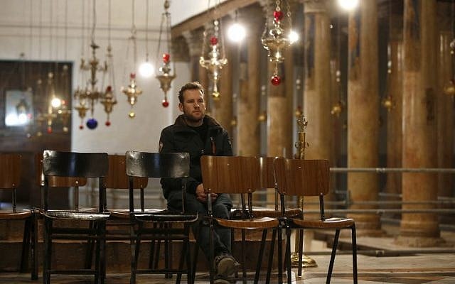 A Christian worshipper sits inside the Church of the Nativity in the biblical West Bank city of Bethlehem, on December 24,2018. (HAZEM BADER/AFP) A Christian worshipper sits inside the Church of the Nativity in the biblical West Bank city of Bethlehem, on December 24,2018. (HAZEM BADER/AFP)
