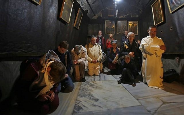 Christian pilgrims pray inside the Grotto, believed to be the exact spot where Jesus Christ was born, at the Church of the Nativity in the biblical West Bank city of Bethlehem, on Christmas eve, December 24, 2018. (Musa Al SHAER/AFP) Christian pilgrims pray inside the Grotto, believed to be the exact spot where Jesus Christ was born, at the Church of the Nativity in the biblical West Bank city of Bethlehem, on Christmas eve, December 24, 2018. (Musa Al SHAER/AFP)
