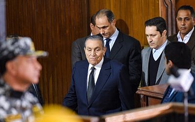 Former Egyptian president Hosni Mubara (center-front), who was ousted following a popular uprising in 2011, arrives with his two sons Gamal (C-behind) and Alaa (2nd-R) to testify during a session in the retrial of members of the now-banned Muslim Brotherhood over charges of plotting jailbreaks and attacks on police during the 2011 uprising, at a make-shift courthouse in southern Cairo on December 26, 2018. (Mohamed el-Shahed/AFP)