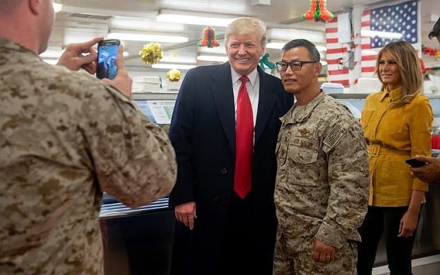 US President Donald Trump and First Lady Melania Trump greet members of the US military during an unannounced trip to Al Asad Air Base in Iraq on December 26, 2018. Posing for a photo with Trump is Lieutenant Commander Kyu Lee, who said he is the chaplain of Navy SEAL Team Five. (Saul Loeb/AFP) US President Donald Trump and First Lady Melania Trump greet members of the US military during an unannounced trip to Al Asad Air Base in Iraq on December 26, 2018. Posing for a photo with Trump is Lieutenant Commander Kyu Lee, who said he is the chaplain of Navy SEAL Team Five. (Saul Loeb/AFP)