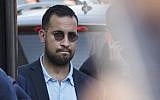 This file photo taken on July 16, 2018 shows Elysee senior security officer Alexandre Benalla standing next to a bus and the plane transporting the France's national soccer team at the Roissy-Charles de Gaulle airport on the outskirts of Paris. (Photo by Thomas SAMSON / AFP)