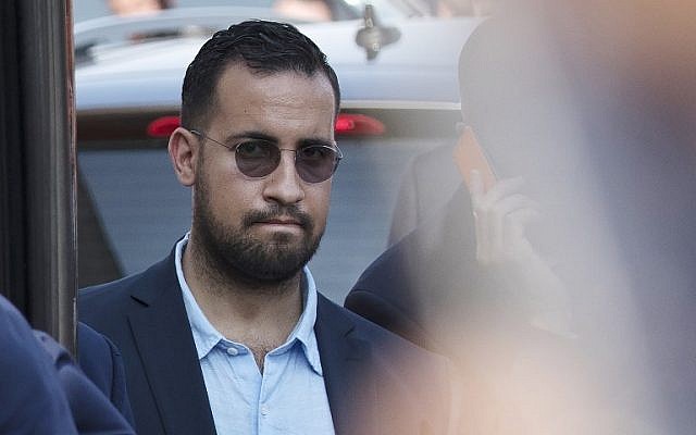 This file photo taken on July 16, 2018 shows Elysee senior security officer Alexandre Benalla standing next to a bus and the plane transporting the France's national soccer team at the Roissy-Charles de Gaulle airport on the outskirts of Paris. (Photo by Thomas SAMSON / AFP) This file photo taken on July 16, 2018 shows Elysee senior security officer Alexandre Benalla standing next to a bus and the plane transporting the France's national soccer team at the Roissy-Charles de Gaulle airport on the outskirts of Paris. (Photo by Thomas SAMSON / AFP)