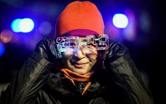 A woman waits for celebrating the New Year during a New Year's Eve countdown event in front of Beijing's National Stadium, known as the Bird's Nest, in Beijing on December 31, 2018. (WANG ZHAO / AFP)