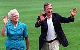 In this Aug. 24, 1992, file photo, President George H.W. Bush and first lady Barbara Bush walk with their dog Millie across the South Lawn as they return to the White House (AP Photo/Scott Applewhite, File)