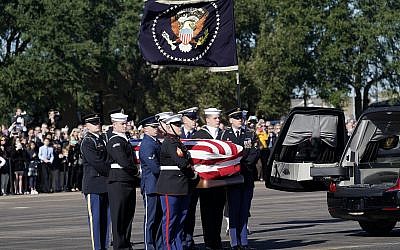 The flag-draped casket of former US President George H.W. Bush is carried by a joint services military honor guard to Special Air Mission 41 at Ellington Field during a departure ceremony on December 3, 2018, in Houston. (AP Photo/David J. Phillip, Pool)