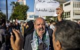 A Tunisian holds an anti-Israel posters reading "Palestine is Arab, No other choice than rifles", outside the Tunisian Tourism Ministry in Tunis, Saturday, Dec. 8, 2018. (AP/Hassene Dridi)