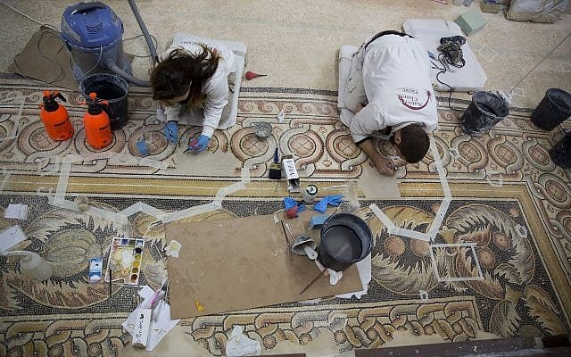 Restoration experts work on a mosaic inside the Church of the Nativity in the West Bank City of Bethlehem, December 6, 2018. (Majdi Mohammed/AP) Restoration experts work on a mosaic inside the Church of the Nativity in the West Bank City of Bethlehem, December 6, 2018. (Majdi Mohammed/AP)