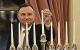 Polish President Andrzej Duda lights the menorah celebrating Hanukkah, the Jewish festival of lights, at the presidential palace in Warsaw, Poland, December 9, 2018. (AP Photo/Alik Keplicz)