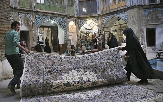 In this photo from December 10, 2018, two carpet weavers open their hand-woven carpet at the grand bazaar in Kashan, Iran. (AP Photo/Vahid Salemi) In this photo from December 10, 2018, two carpet weavers open their hand-woven carpet at the grand bazaar in Kashan, Iran. (AP Photo/Vahid Salemi)