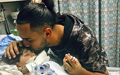 This recent but undated photo, released Dec. 17, 2018, by the Council on American-Islamic Relations in Sacramento, Calif., shows Ali Hassan kissing his dying 2-year-old son Abdullah in a Sacramento hospital (Council on American-Islamic Relations via AP)