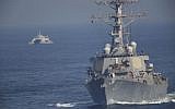 The USS Mitscher, part of a strike group led by the USS John C. Stennis aircraft carrier, sails as an Iranian Revolutionary Guard vessel shadows it on December 21, 2018. (AP Photo/Jon Gambrell)