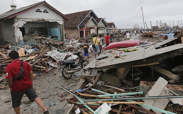 People inspect the damage at a tsunami-ravaged village in Sumur, Indonesia, December 25, 2018. (Tatan Syuflana/AP) People inspect the damage at a tsunami-ravaged village in Sumur, Indonesia, December 25, 2018. (Tatan Syuflana/AP)