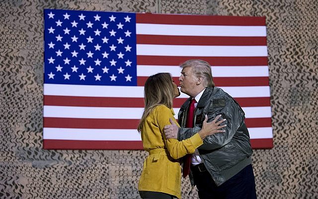 US President Donald Trump kisses first lady Melania Trump during a hanger rally at Al Asad Air Base, Iraq, on December 26, 2018. (AP Photo/Andrew Harnik) US President Donald Trump kisses first lady Melania Trump during a hanger rally at Al Asad Air Base, Iraq, on December 26, 2018. (AP Photo/Andrew Harnik)