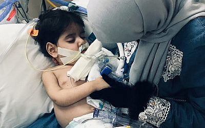 In this December 2018 photo released by the Council on American Islamic Relations, Sacramento Valley, Shaima Swileh, of Yemen, holds her dying 2-year old son Abdullah Hassan at UCSF Benioff Children's Hospital in Oakland, California, USA. (Council on American Islamic Relations, Sacramento Valley via AP)