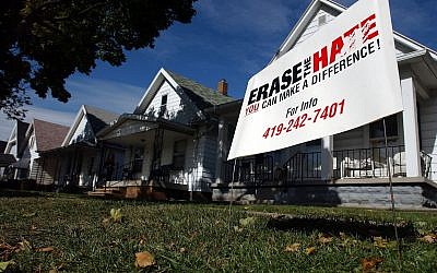 An "Erase the Hate" sign stands in the front lawn of a home, Monday, Oct. 17, 2005, in Toledo, Ohio, near where a mob looted and burned a neighborhood bar, smashed the windows of a gas station, and hurling rocks and bottles at police on Saturday. (AP/J.D. Pooley)