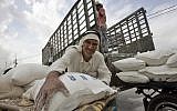 A Palestinian man loads flour bags onto a donkey cart outside the United Nations World Food Programme distribution center in the Rafah refugee camp, southern Gaza Strip, Nov. 7, 2007 (AP Photo/Khalil Hamra)