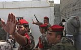 Palestinian police officers gesture to journalists as they display three Palestinian men, standing against the wall at right, for the media after they were convicted by a tribunal of collaborating with Israel in the West Bank city of Hebron, Tuesday, Oct. 14, 2008. (AP/Nasser Shiyoukhi)