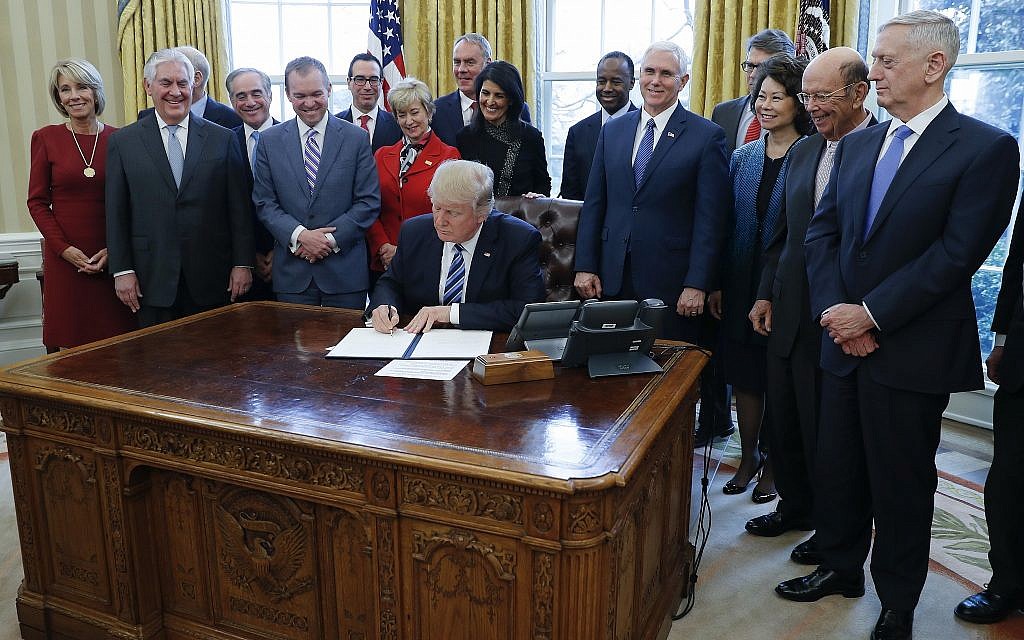 President Donald Trump signs an executive order in the Oval Office of the White House in Washington, Monday, March 13, 2017. From left are Education Secretary Betsy DeVos, Homeland Security Secretary John Kelly, Secretary of State Rex Tillerson, Veterans Affairs Secretary David Shulkin, Budget Director Mick Mulvaney, Treasury Secretary Steve Mnuchin, Small Business Administration Administrator Linda McMahon, Interior Secretary Ryan Zinke, UN Ambassador Nikki Haley, Housing and Urban Development Secretary Ben Carson, Vice President Mike Pence, Energy Secretary Rick Perry, Transportation Secretary Elaine Chao, Commerce Secretary Wilbur Ross, and Defense Secretary James Mattis. (AP Photo/Pablo Martinez Monsivais) President Donald Trump signs an executive order in the Oval Office of the White House in Washington, Monday, March 13, 2017. From left are Education Secretary Betsy DeVos, Homeland Security Secretary John Kelly, Secretary of State Rex Tillerson, Veterans Affairs Secretary David Shulkin, Budget Director Mick Mulvaney, Treasury Secretary Steve Mnuchin, Small Business Administration Administrator Linda McMahon, Interior Secretary Ryan Zinke, UN Ambassador Nikki Haley, Housing and Urban Development Secretary Ben Carson, Vice President Mike Pence, Energy Secretary Rick Perry, Transportation Secretary Elaine Chao, Commerce Secretary Wilbur Ross, and Defense Secretary James Mattis. (AP Photo/Pablo Martinez Monsivais)
