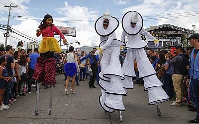 Performers on stilts dance for the crowd during the Founders' Anniversary Festival in Tegucigalpa, Honduras, Saturday, Sept. 22, 2018. (AP/Fernando Antonio)
