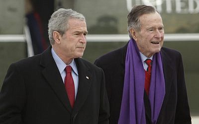 In this December 26, 2008 file photo, US President George W. Bush walks with his father, former President George H.W. Bush, at Andrews Air Force Base, Maryland. (AP Photo/Evan Vucci, File)
