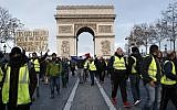 Demonstrators wearing yellow vests march down the Champs Elysees avenue Saturday, Dec. 8, 2018 in Paris (AP Photo/Thibault Camus)