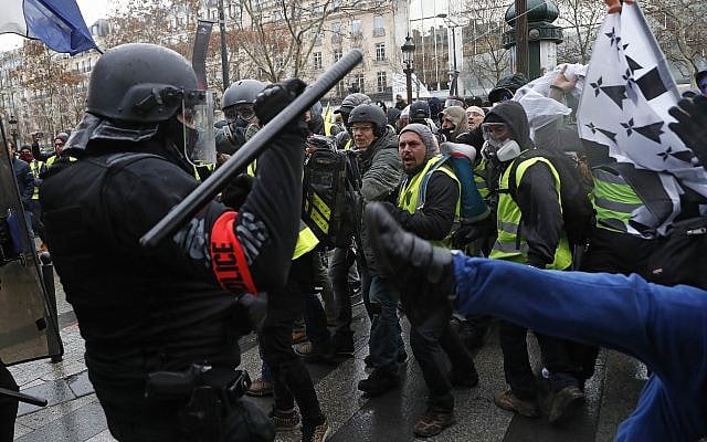Police officers clash with demonstrators wearing yellow vests in Paris on December 8, 2018 (AP Photo/Thibault Camus)