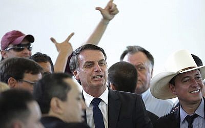 Brazil's president-elect Jair Bolsonaro, center, poses for photos during a lunch with popular singers who supported his campaign, at the Army Club, in Brasilia, Brazil, Tuesday, Dec. 11, 2018. (AP/Eraldo Peres)