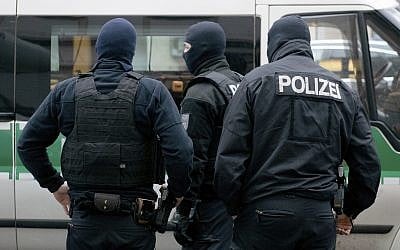 Police officer stand in front of a mosque in Berlin on Dec. 18, 2018, which is searched as part of an investigation into its imam on suspicion he raised money to support an Islamic fighter in Syria (Paul Zinken/dpa via AP)