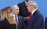 In this photo from November 30, 2018, US President Donald Trump, right, walks past Russia's President Vladimir Putin, left, as they gather for the group photo at the start of the G20 summit in Buenos Aires, Argentina. (AP Photo/Pablo Martinez Monsivais, File