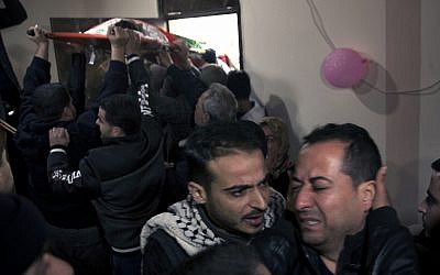 Relatives of 16 year-old Palestinian Mohammed Jahjouh, who was said to have been shot and killed by Israeli troops during a protest at the Gaza Strip's border with Israel, mourn as others carry his body into the family home during his funeral in Gaza City, December 22, 2018. (AP Photo/Khalil Hamra)