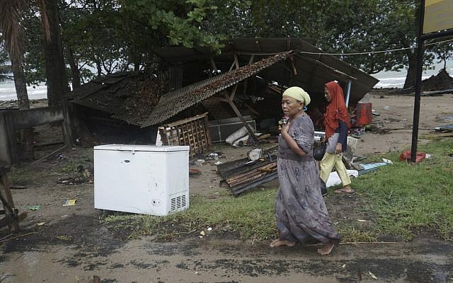 Residents walk past a house damaged by a tsunami, in Carita, Indonesia, December 23, 2018. (AP Photo/Dian Triyuli Handoko) Residents walk past a house damaged by a tsunami, in Carita, Indonesia, December 23, 2018. (AP Photo/Dian Triyuli Handoko)